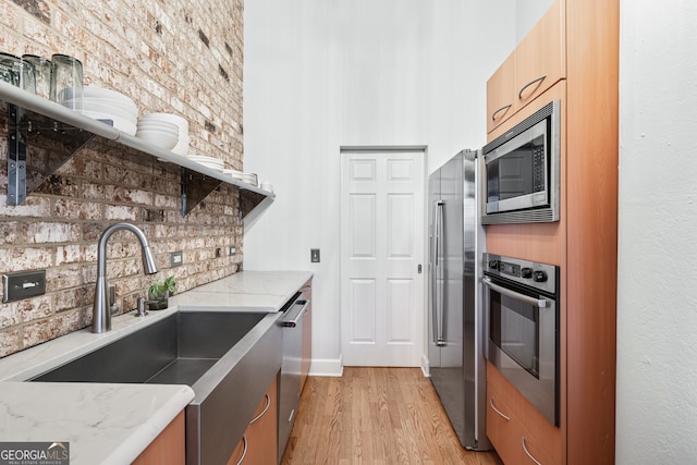 3820 Roswell Rd NE Unit 705, Atlanta, GA 30342 - kitchen featuring stainless steel appliances, a sink, light wood finished floors, light stone countertops, and tasteful backsplash