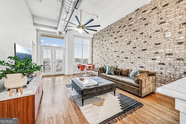 3820 Roswell Rd NE Unit 705, Atlanta, GA 30342 - living area featuring light wood finished floors, ceiling fan, a high ceiling, brick wall, and french doors