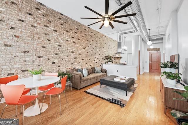 3820 Roswell Rd NE Unit 705, Atlanta, GA 30342 - living area with brick wall, ceiling fan, and light wood-style flooring