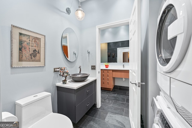 3820 Roswell Rd NE Unit 705, Atlanta, GA 30342 - bathroom featuring stacked washer / dryer, two vanities, and toilet
