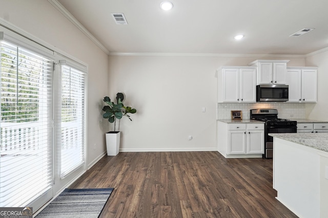 kitchen with white cabinets, stainless steel appliances, decorative backsplash, visible vents, and dark wood-style floors
