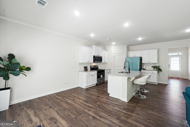 kitchen featuring visible vents, crown molding, stainless steel microwave, freestanding refrigerator, and gas range oven