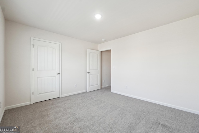 unfurnished bedroom with carpet flooring and baseboards