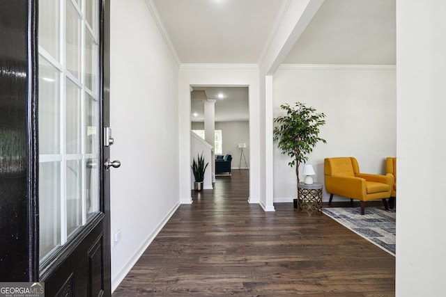foyer with crown molding, baseboards, and dark wood finished floors