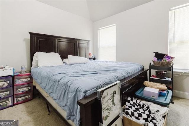 bedroom with carpet floors and lofted ceiling