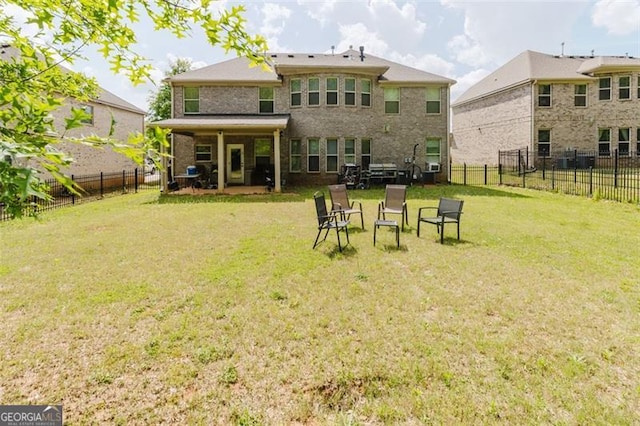 back of property with a lawn, a fenced backyard, and brick siding