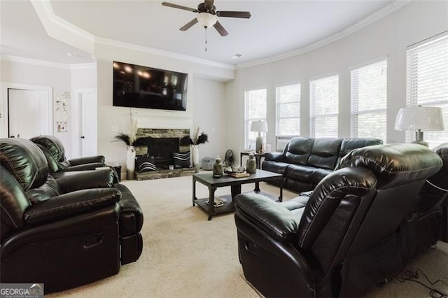 living room featuring light colored carpet, ornamental molding, ceiling fan, and a stone fireplace