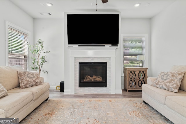 living area featuring visible vents, wood finished floors, ceiling fan, recessed lighting, and a tile fireplace