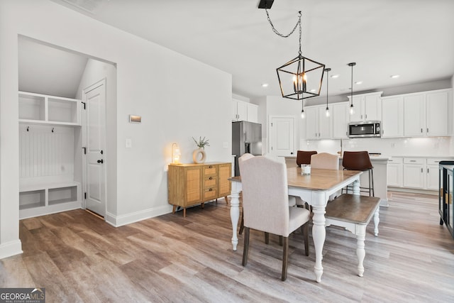 dining room featuring recessed lighting, baseboards, an inviting chandelier, and light wood-style floors