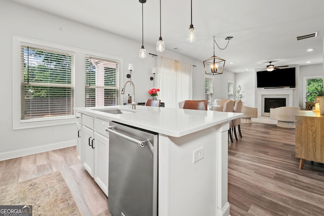 kitchen featuring a sink, light wood finished floors, white cabinetry, stainless steel dishwasher, and visible vents