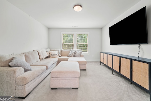 living area featuring baseboards, visible vents, and light carpet