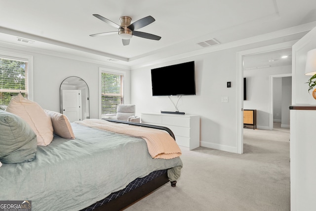 bedroom featuring carpet floors, multiple windows, a raised ceiling, and visible vents