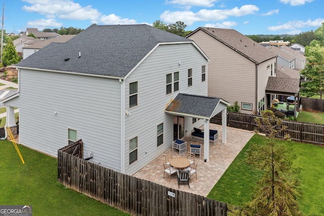 rear view of property featuring a yard, a residential view, a fenced backyard, and a patio area