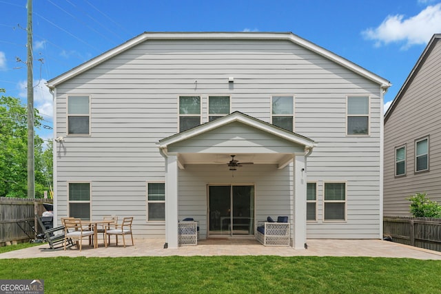 back of property with a ceiling fan, a patio area, a fenced backyard, and a yard