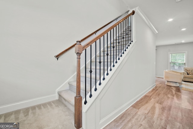stairway with recessed lighting, baseboards, and wood finished floors