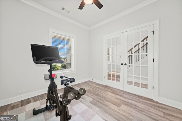 exercise area featuring visible vents, crown molding, wood finished floors, baseboards, and a ceiling fan