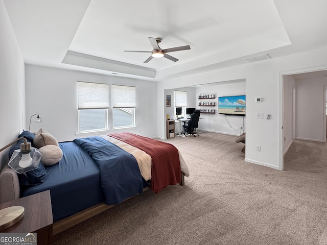 bedroom with carpet floors, a ceiling fan, baseboards, and a tray ceiling