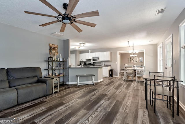 150 Buckeye Trails Dr, Commerce, GA 30530 - living room featuring ceiling fan with notable chandelier, dark wood-style flooring, a textured ceiling, and visible vents