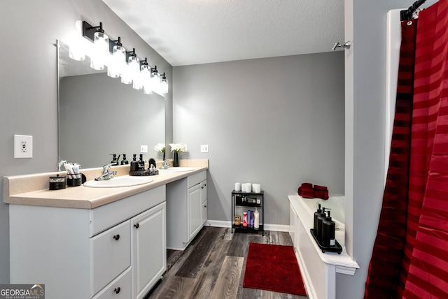 150 Buckeye Trails Dr, Commerce, GA 30530 - full bath featuring a textured ceiling, vanity, a garden tub, and wood finished floors