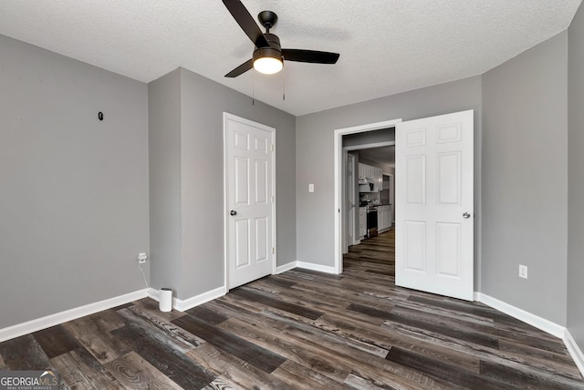 150 Buckeye Trails Dr, Commerce, GA 30530 - unfurnished bedroom featuring a ceiling fan, a textured ceiling, dark wood-style floors, and baseboards
