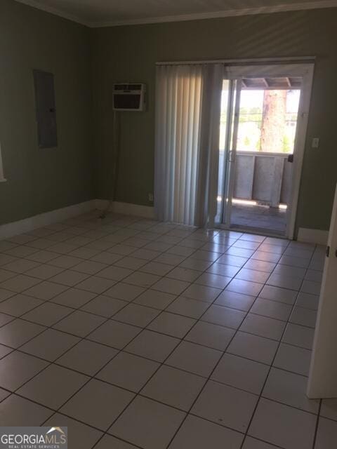 spare room with light tile patterned floors, baseboards, electric panel, and a wall mounted air conditioner