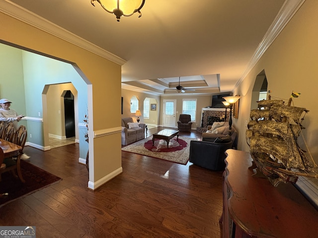 108 Hope Ln, Cedartown, GA 30125 - living room with ornamental molding, a brick fireplace, arched walkways, a raised ceiling, and dark wood-style floors