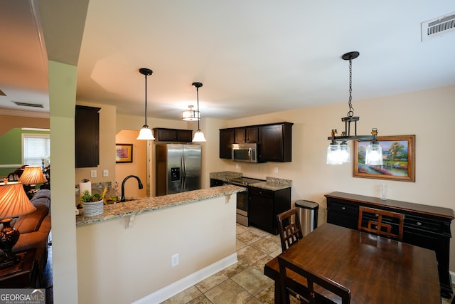 108 Hope Ln, Cedartown, GA 30125 - kitchen featuring a peninsula, stainless steel appliances, visible vents, light stone countertops, and decorative light fixtures