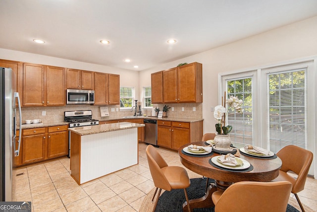 kitchen with backsplash, a center island, stainless steel appliances, recessed lighting, and light tile patterned flooring