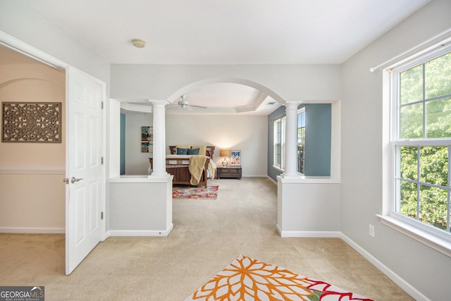bedroom featuring ornate columns, arched walkways, baseboards, and light carpet