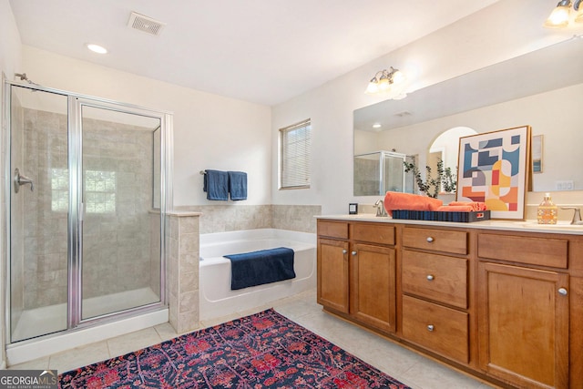 full bath with visible vents, tile patterned flooring, double vanity, a shower stall, and a sink