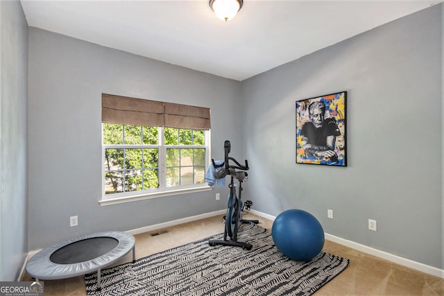 exercise room featuring visible vents, carpet flooring, and baseboards