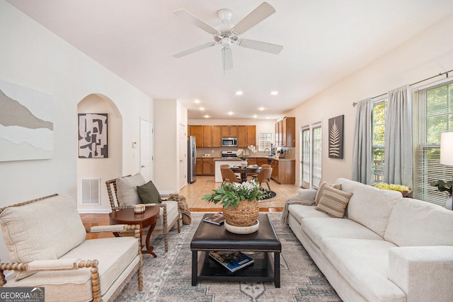 living room with plenty of natural light, recessed lighting, arched walkways, and visible vents