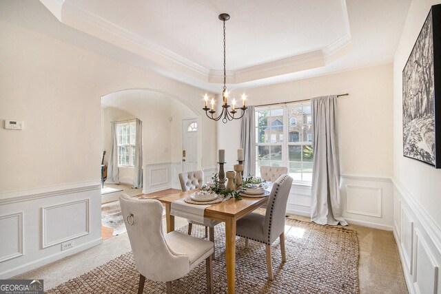 dining space with arched walkways, wainscoting, and a decorative wall