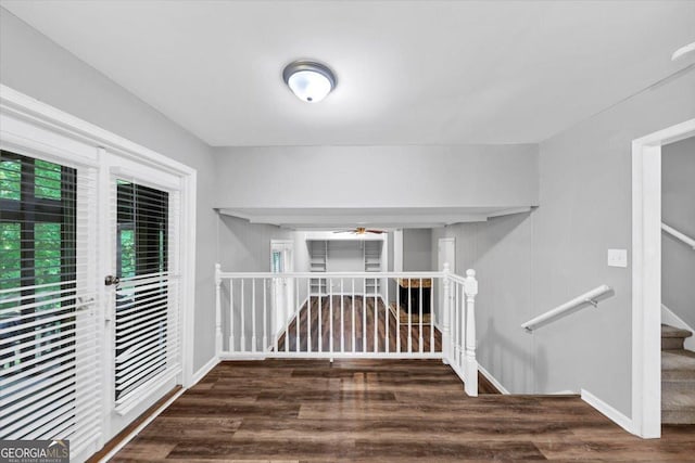 interior space featuring baseboards, a ceiling fan, and wood finished floors