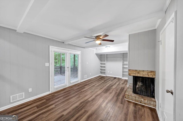 unfurnished living room featuring a brick fireplace, dark wood finished floors, a ceiling fan, beamed ceiling, and visible vents