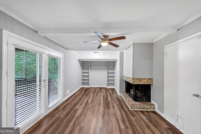 unfurnished living room featuring ceiling fan, ornamental molding, beam ceiling, and wood finished floors