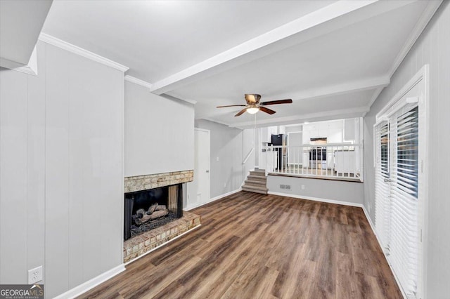 unfurnished living room with a ceiling fan, a brick fireplace, baseboards, dark wood-style floors, and stairs