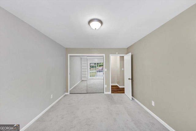 unfurnished bedroom featuring carpet flooring, baseboards, and a closet