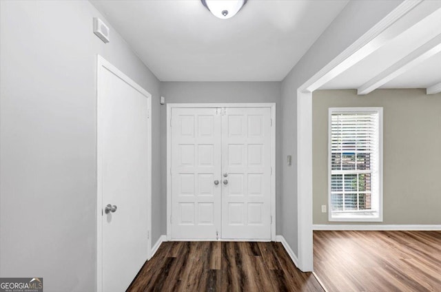 foyer featuring baseboards and dark wood finished floors