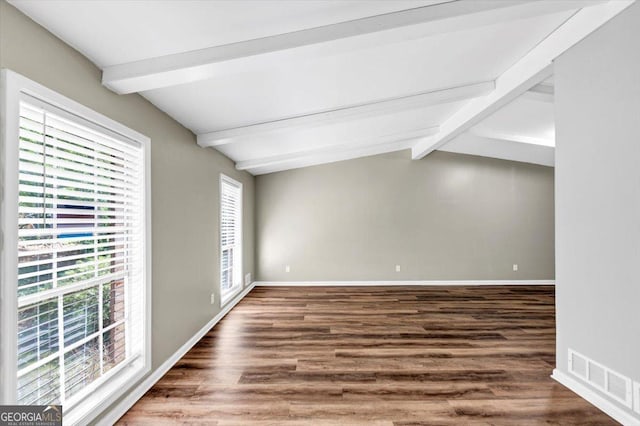 spare room with baseboards, lofted ceiling with beams, wood finished floors, and visible vents