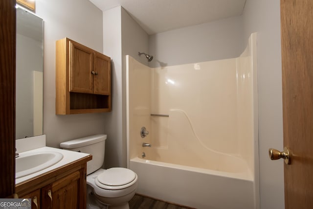 bathroom featuring vanity, wood finished floors, toilet, and shower / washtub combination