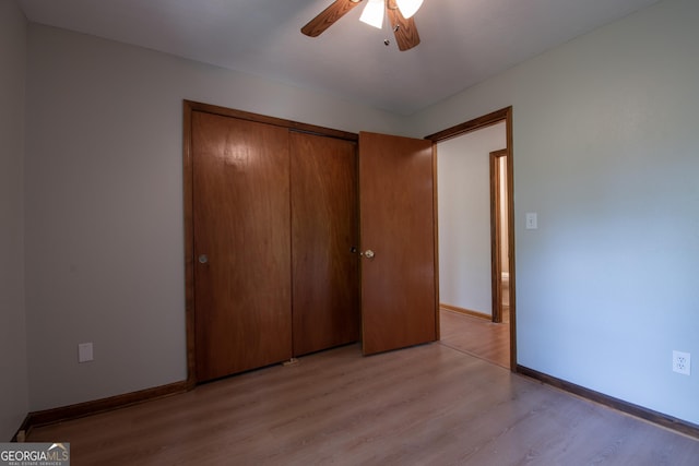 unfurnished bedroom with baseboards, ceiling fan, a closet, and light wood finished floors