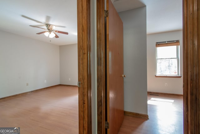 hallway with baseboards and light wood-style flooring