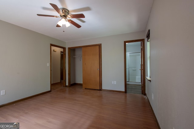 unfurnished bedroom featuring baseboards, ensuite bathroom, a closet, and light wood-type flooring