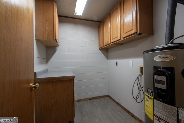 laundry area with electric dryer hookup, wood finished floors, cabinet space, baseboards, and electric water heater