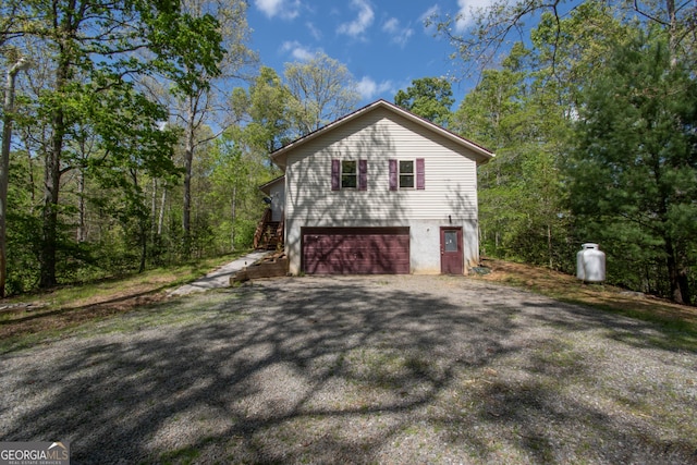 view of property exterior with a garage and aphalt driveway