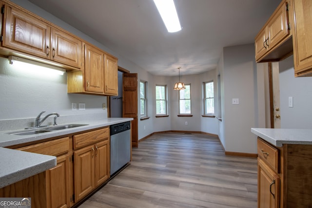 kitchen featuring light wood-style floors, light countertops, a sink, dishwasher, and hanging light fixtures