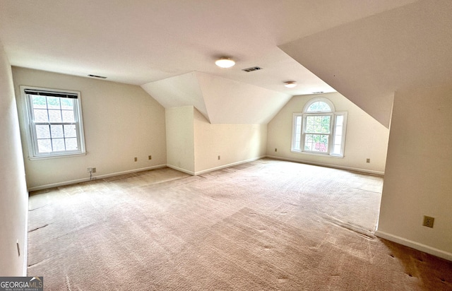 additional living space with carpet flooring, lofted ceiling, and baseboards