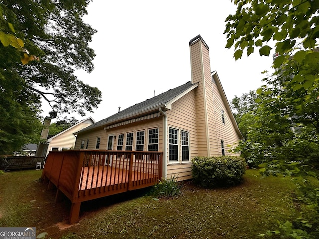 back of house with a deck and a chimney