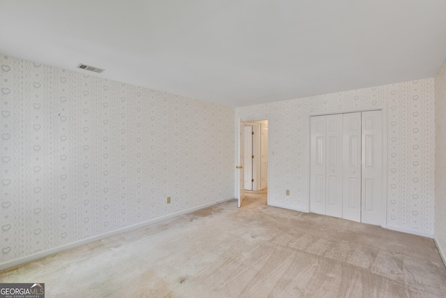 4481 Mccart Cv, Stone Mountain, GA 30083 - unfurnished bedroom featuring wallpapered walls, carpet flooring, and a closet